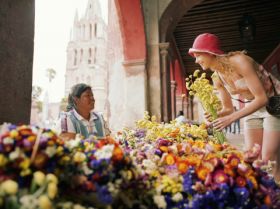 Expat woman buying flowers from local Mexican in San Miguel de Allende – Best Places In The World To Retire – International Living