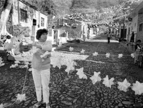 Woman hanging decorations on street in Ajijic, 1950s – Best Places In The World To Retire – International Living