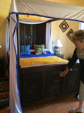 Woman showing hand carved bed footer in Mexico