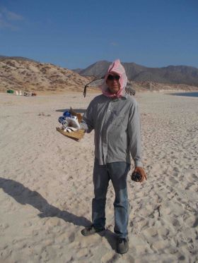 Man collecting garbage on beach in Baja California Sur